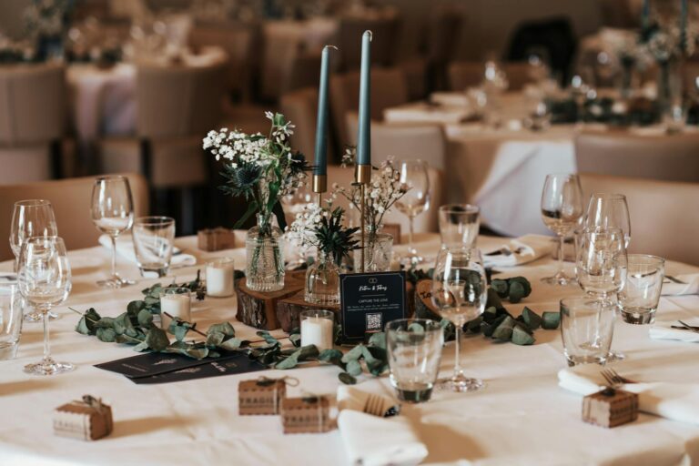 A beautifully decorated wedding reception table with candles and floral arrangements.