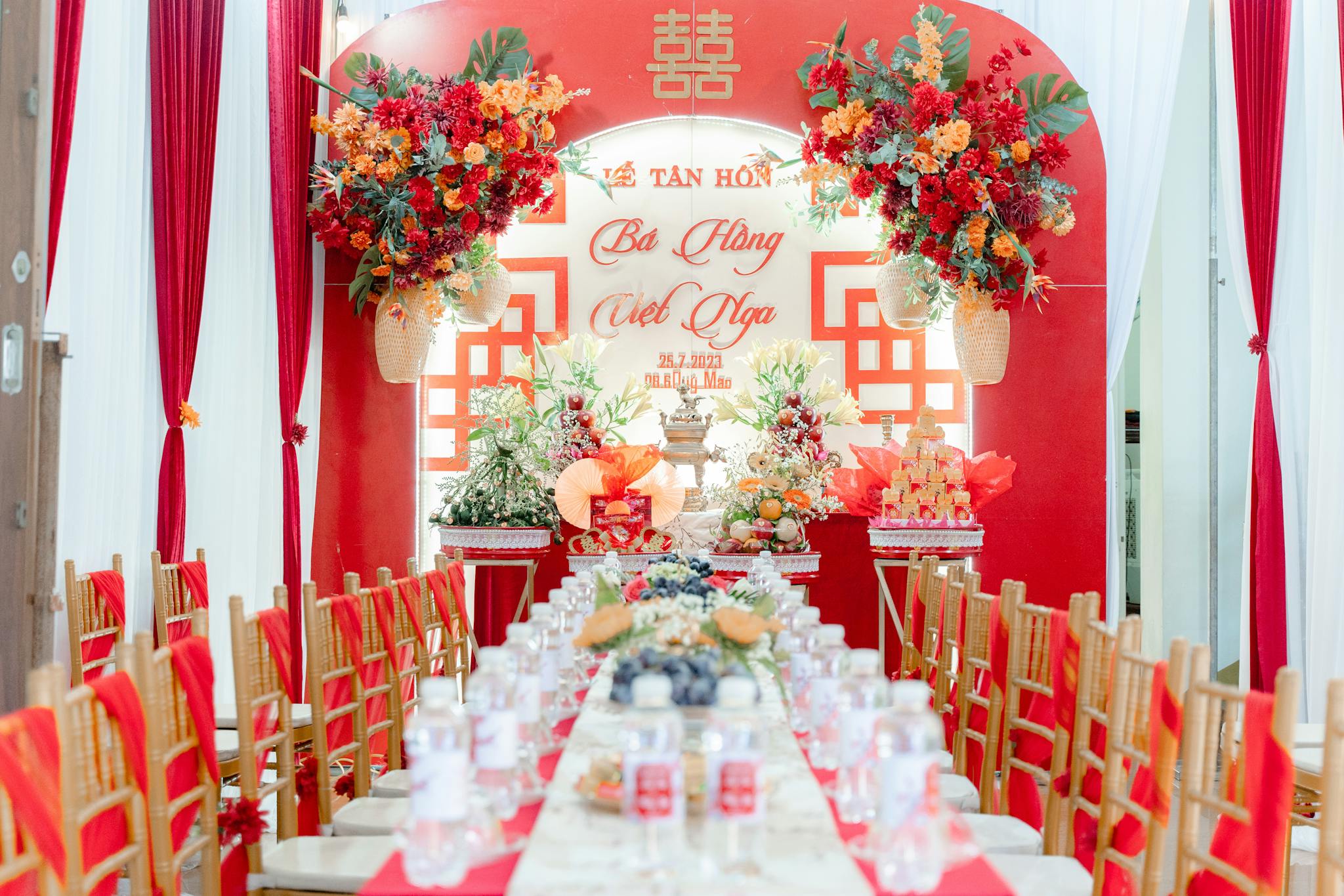 Vibrant wedding reception setup with red decor and floral arrangements.